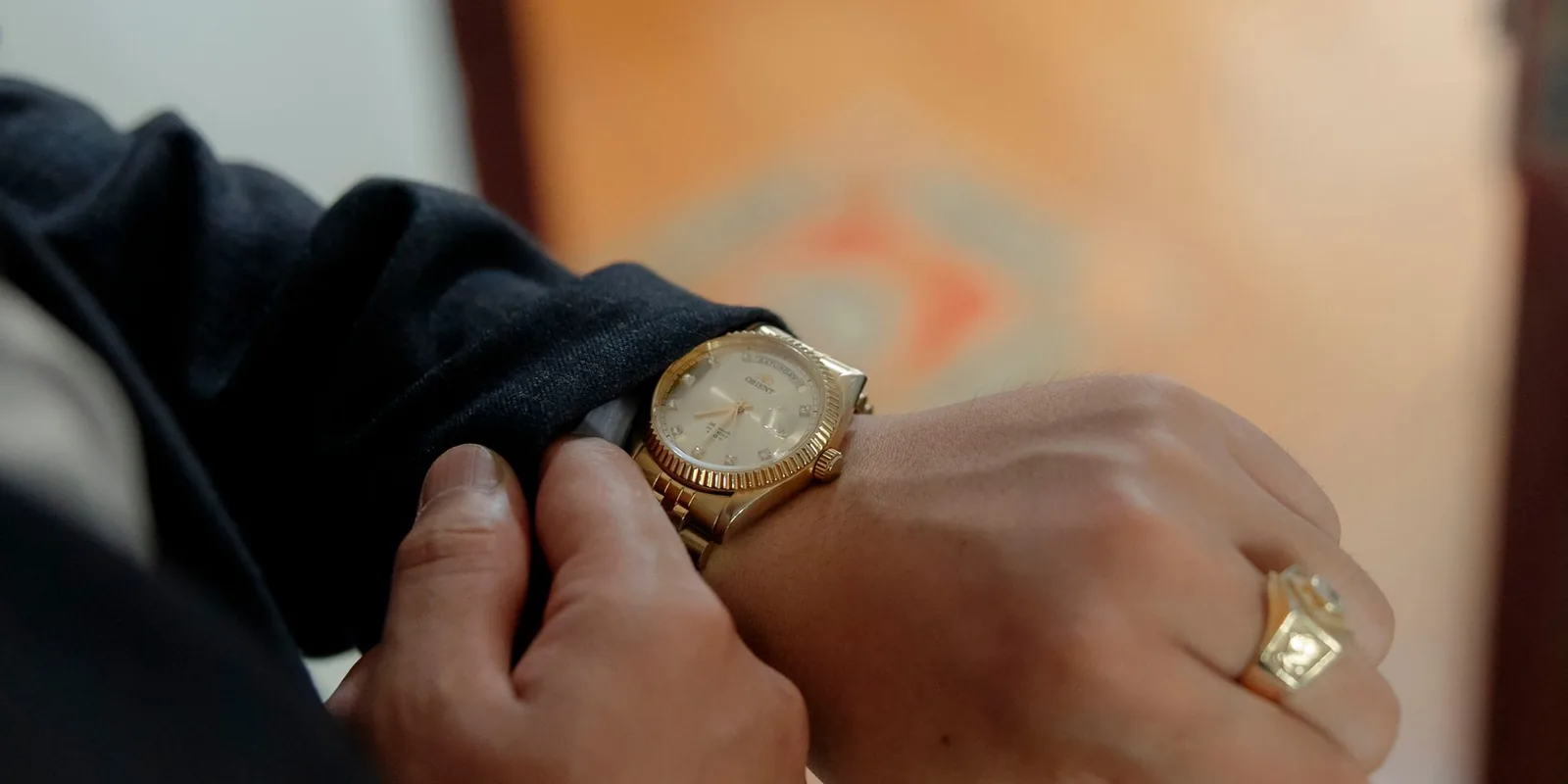 Close-up of a luxurious gold wristwatch on a person's wrist, highlighting elegance and style