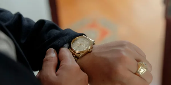 Close-up of a luxurious gold wristwatch on a person's wrist, highlighting elegance and style