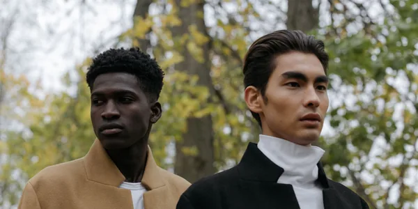 Two stylish men outdoors in autumn, showcasing elegant fashion trends