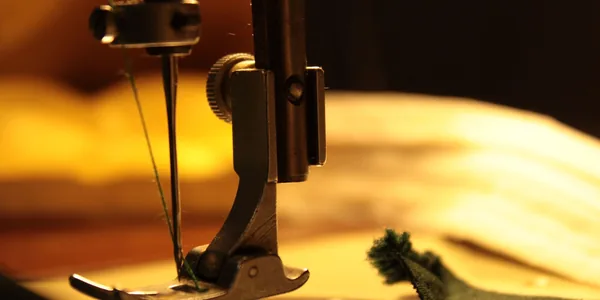 Detailed view of a sewing machine needle stitching fabric, highlighting craftsmanship