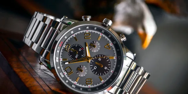 Luxury wristwatch with stainless steel bracelet displayed elegantly on a wooden background