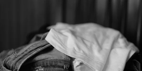 Monochrome image showcasing a close-up of folded jeans and t-shirt