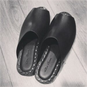 Black and white image of dark leather sandals
