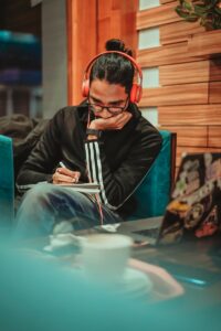 man in black jacket sitting on chair wearing red headphones