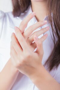 woman in white shirt rubbing hands
