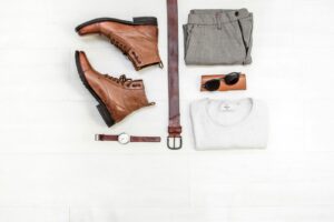 pair of brown leather boots beside belt