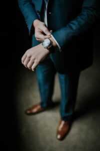 man holding the cuff of his black suit