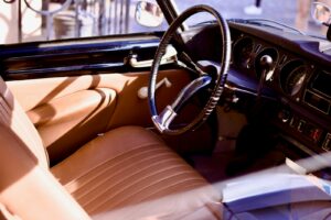 The interior of a car with a steering wheel and dashboard