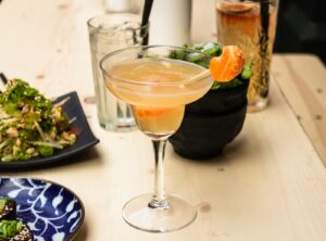 beverage filled clear cocktail glass on wooden surface