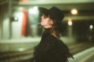 Woman wearing a black cowboy hat and black poncho with sunglasses