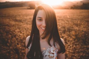 A woman lookin directly at the camera with dark hair covering one eye